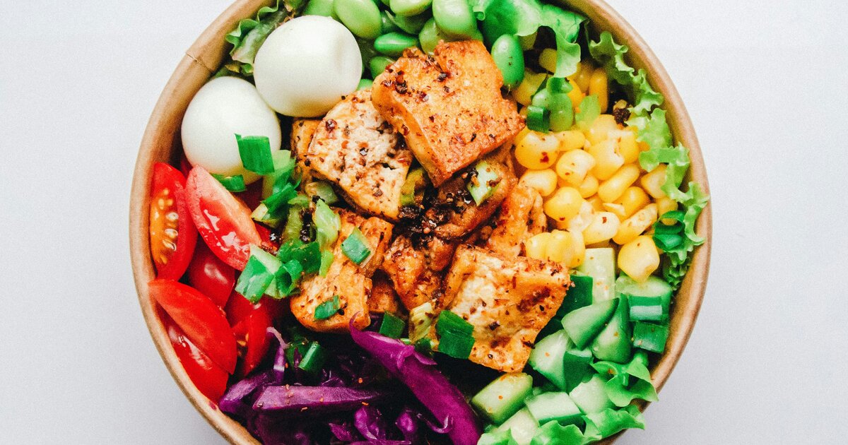 Bowl colorido com frango grelhado, vegetais e ovo cozido — exemplo de receita alto-proteína do PDF gratuito MagroFeed